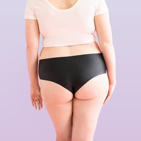 The backside of a woman who is wearing Lorals for STI Protection panties and a white t-shirt |Shortie
