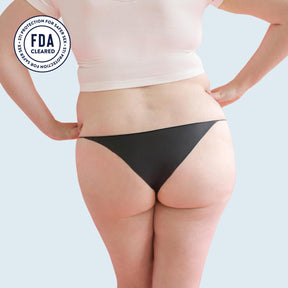Lorals model Amanda demonstrates the back view of Black Latex STI Protection Panties in Bikini Style