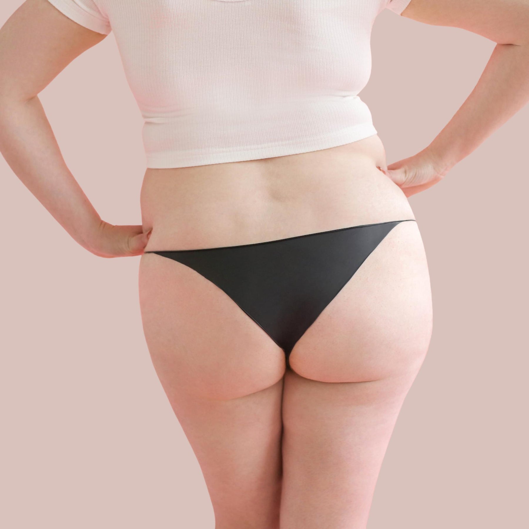 Lorals model Amanda demonstrates the back view of Black Latex Panties in Bikini Style