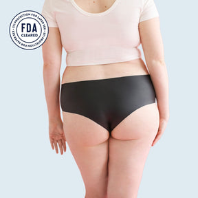 The backside of a woman who is wearing Lorals for STI Protection panties and a white t-shirt |Shortie